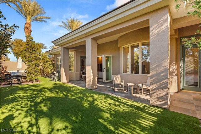 back of house with a lawn and a patio