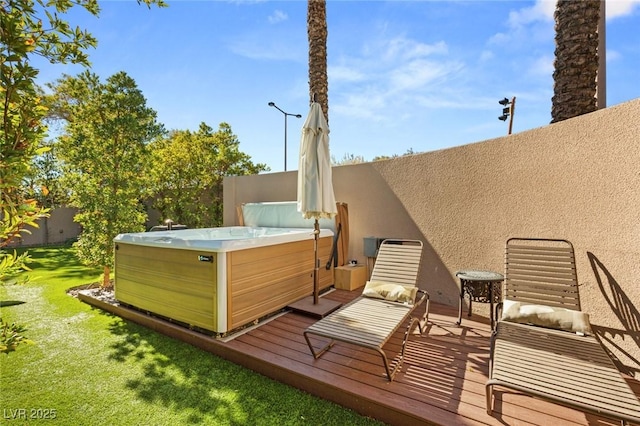 wooden terrace featuring a lawn and a hot tub