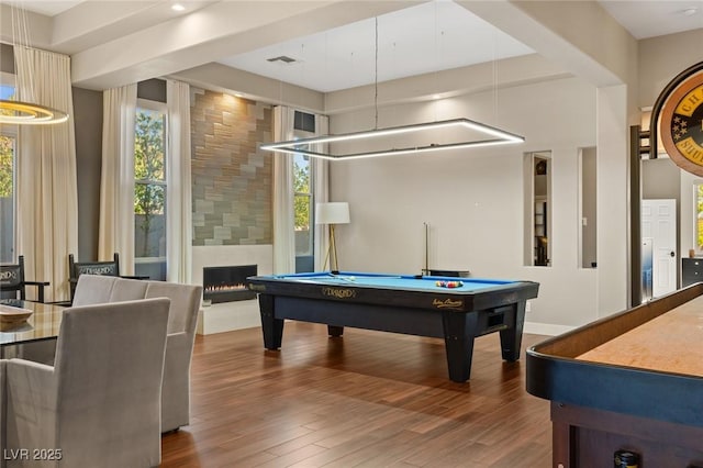 playroom with pool table, hardwood / wood-style flooring, a high ceiling, and a large fireplace