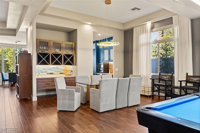 dining space with dark hardwood / wood-style flooring and bar