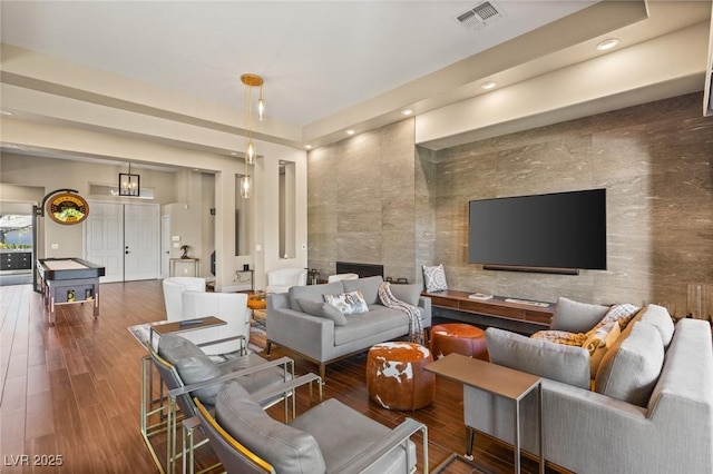 living room featuring hardwood / wood-style floors and tile walls