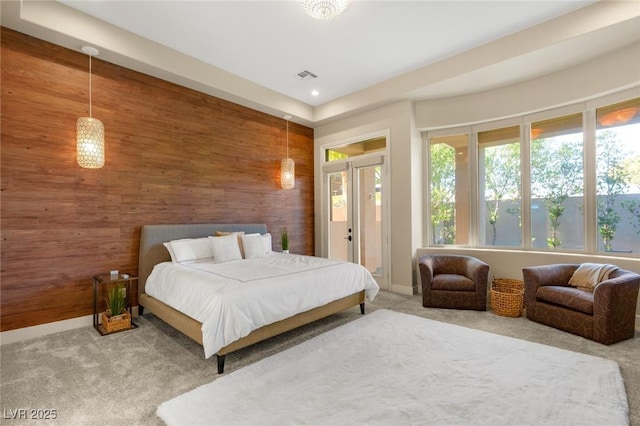 carpeted bedroom with wood walls