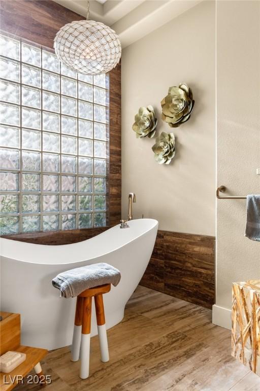 bathroom with hardwood / wood-style floors, a bathtub, and a healthy amount of sunlight