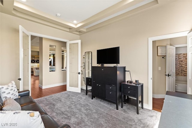 living room with french doors, dark carpet, and a raised ceiling