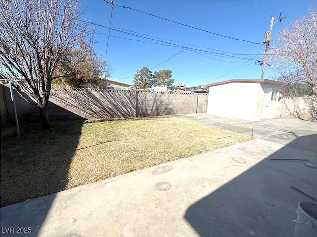 view of yard with a patio area, a fenced backyard, and an outdoor structure