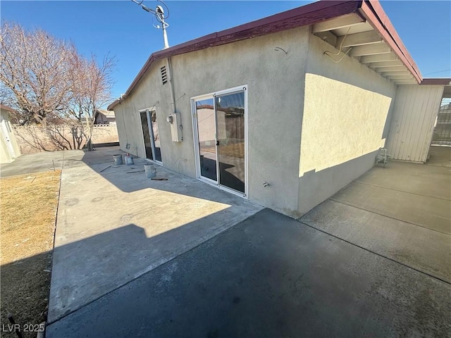 back of house featuring a patio, fence, and stucco siding