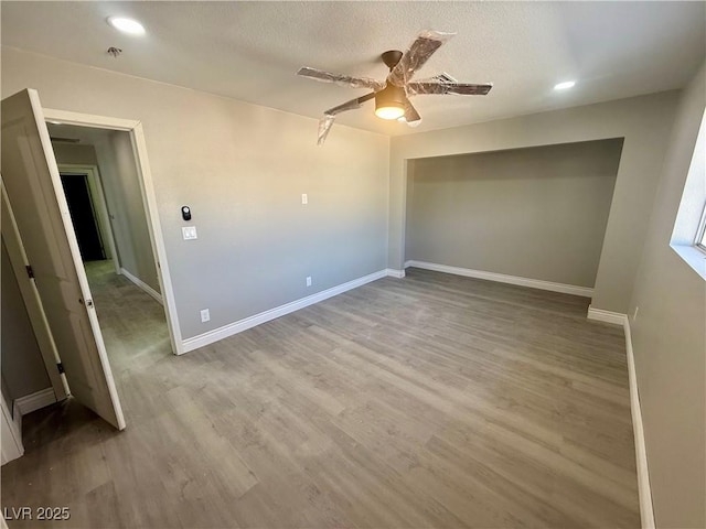 unfurnished bedroom with recessed lighting, ceiling fan, a textured ceiling, wood finished floors, and baseboards