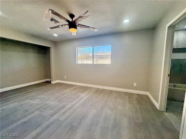 unfurnished bedroom featuring a ceiling fan, a textured ceiling, baseboards, and wood finished floors