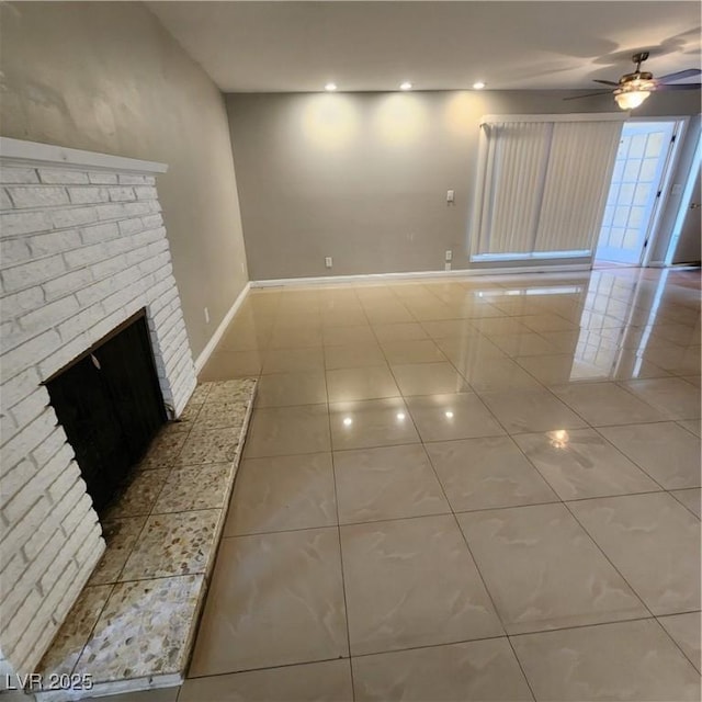 unfurnished living room with a fireplace, tile patterned floors, and ceiling fan