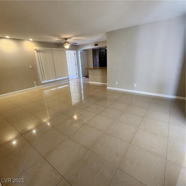 tiled spare room featuring ceiling fan