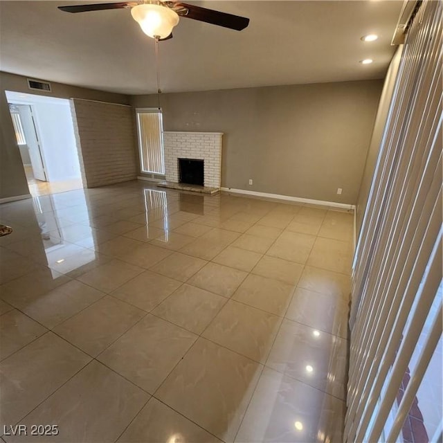 unfurnished living room with ceiling fan, light tile patterned floors, and a fireplace