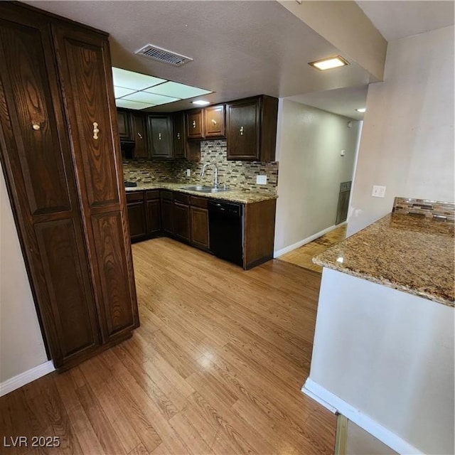 kitchen featuring dark brown cabinets, sink, black dishwasher, light hardwood / wood-style floors, and decorative backsplash