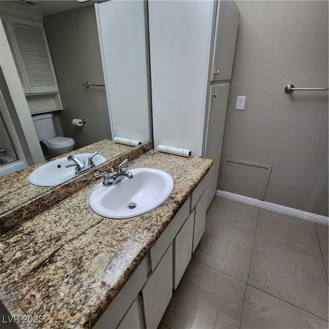 bathroom featuring vanity, toilet, and tile patterned flooring