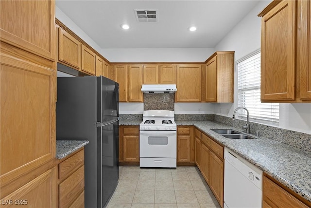 kitchen with sink, light tile patterned flooring, white appliances, and light stone counters