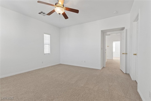 spare room with ceiling fan and light colored carpet