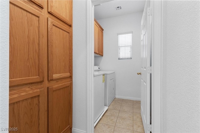 washroom with cabinets, separate washer and dryer, and light tile patterned flooring