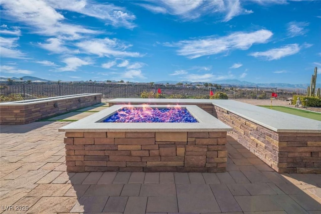 view of swimming pool featuring a mountain view, a fire pit, and a patio area