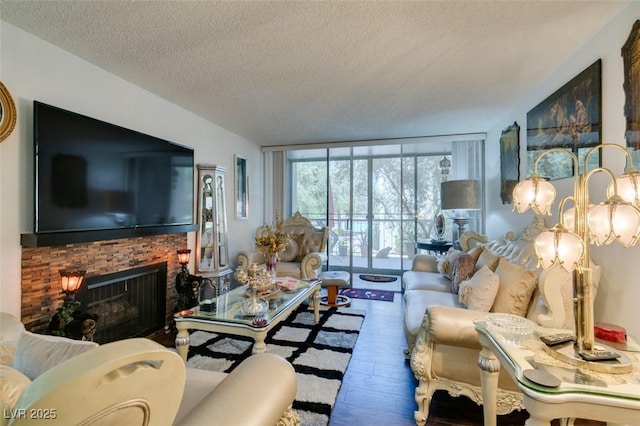 living room with a textured ceiling, expansive windows, hardwood / wood-style floors, and a fireplace