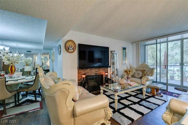 living room with a wall of windows, a fireplace, dark wood-type flooring, and a textured ceiling