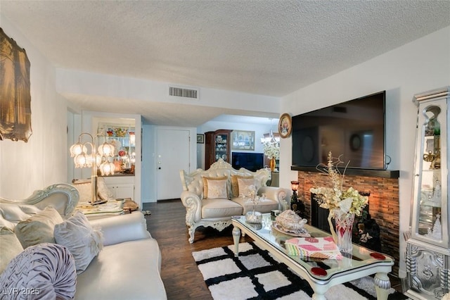 living room with a textured ceiling and dark hardwood / wood-style floors