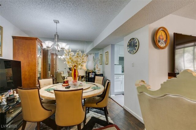 dining space with a textured ceiling, dark hardwood / wood-style floors, and a notable chandelier