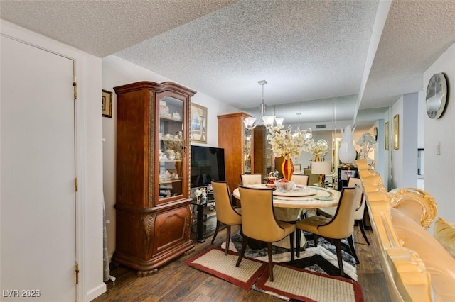 dining area with a chandelier, a textured ceiling, and dark hardwood / wood-style flooring