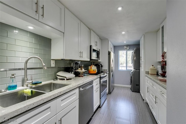 kitchen with sink, white cabinets, appliances with stainless steel finishes, and tasteful backsplash