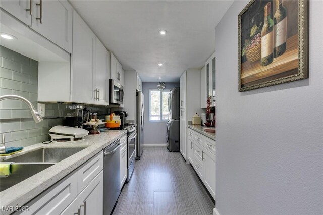 kitchen with white cabinets, backsplash, appliances with stainless steel finishes, and sink