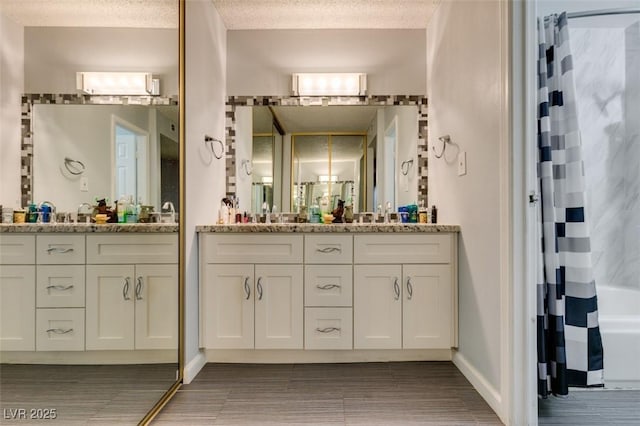 bathroom with vanity, a textured ceiling, and shower / tub combo with curtain