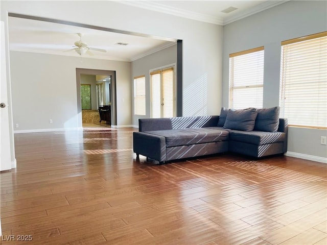 living room with crown molding, plenty of natural light, and wood-type flooring