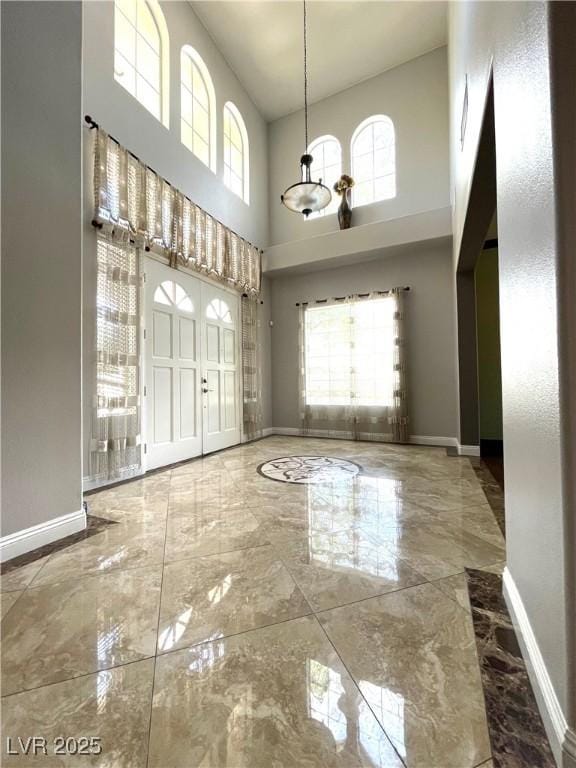 unfurnished dining area with a towering ceiling