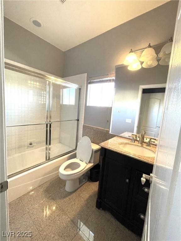 full bathroom with combined bath / shower with glass door, toilet, and vanity