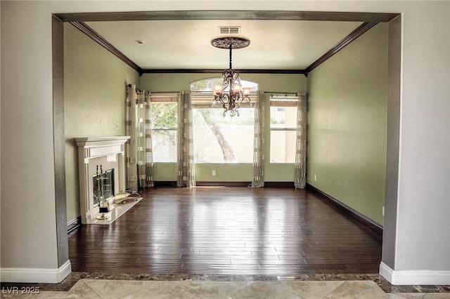 unfurnished living room featuring crown molding, plenty of natural light, and an inviting chandelier