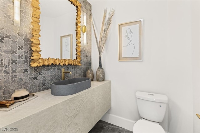 bathroom featuring decorative backsplash, sink, and toilet