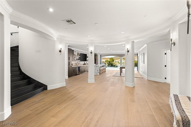 interior space featuring crown molding and light hardwood / wood-style floors