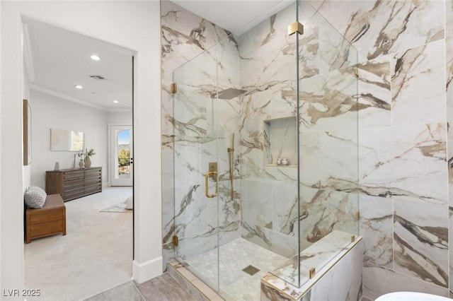 bathroom with vanity, crown molding, and a shower with door