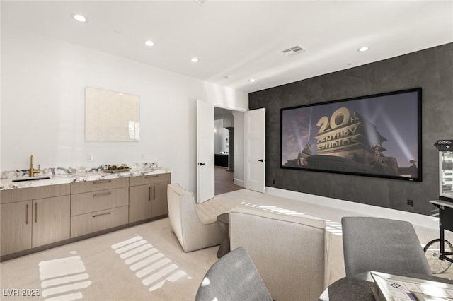 carpeted home theater featuring sink