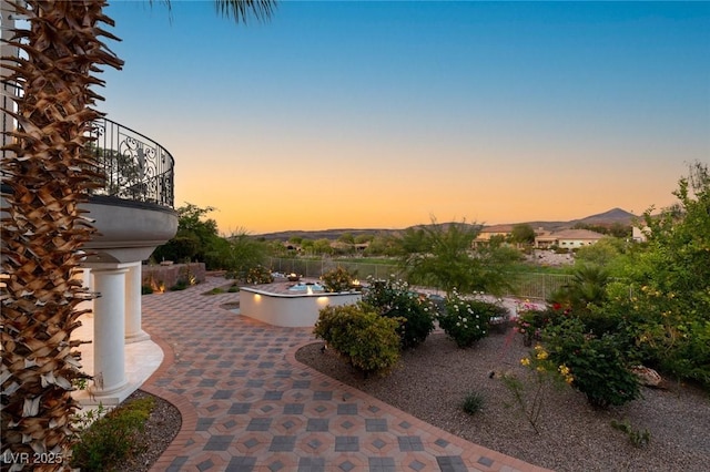 patio terrace at dusk featuring a mountain view