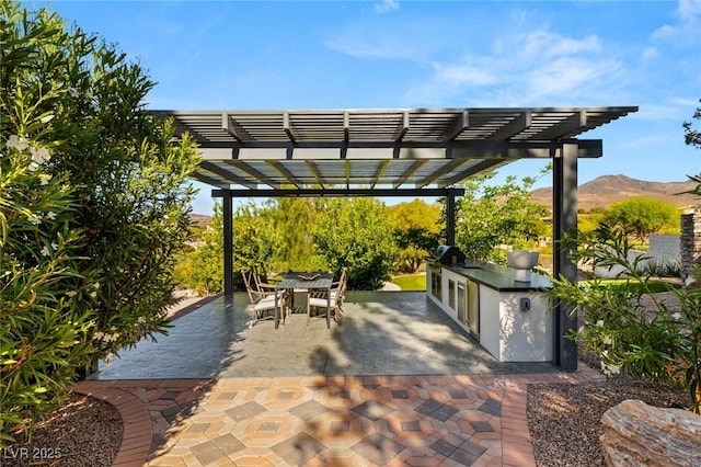 view of patio / terrace with a mountain view, area for grilling, and a pergola