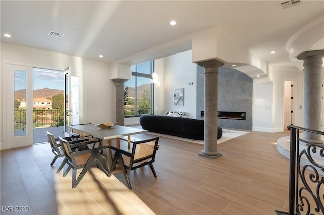 dining space featuring decorative columns, plenty of natural light, a mountain view, and a fireplace