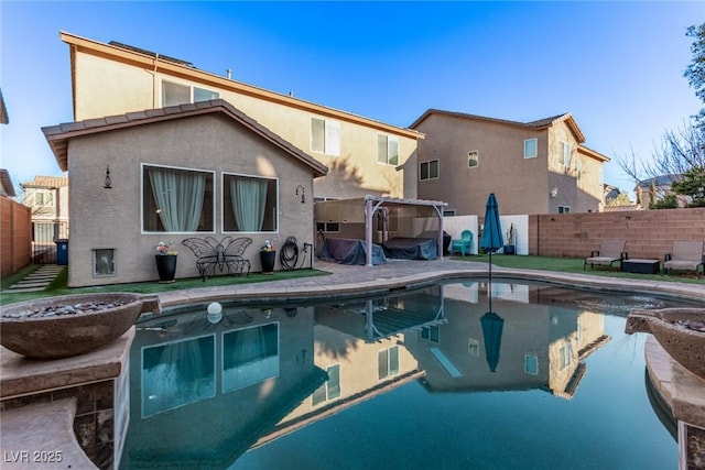 rear view of house with a fenced in pool and a pergola