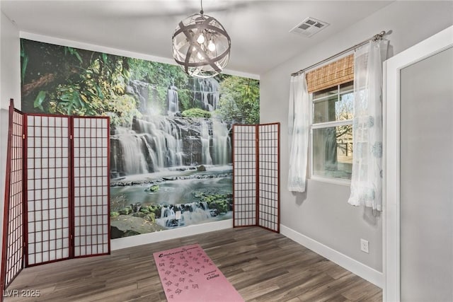 doorway to outside featuring an inviting chandelier and dark hardwood / wood-style floors