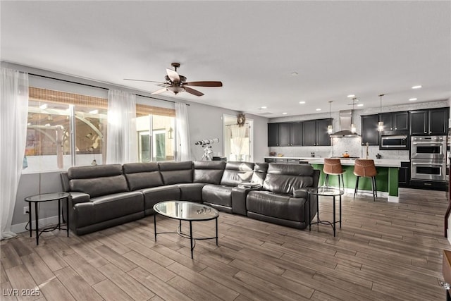 living room featuring wood-type flooring and ceiling fan