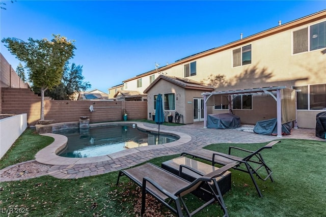 back of house featuring a patio area, a fenced in pool, and a lawn