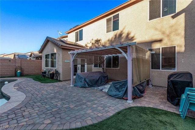 back of property featuring a patio area and a pergola