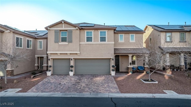 townhome / multi-family property with solar panels and a garage