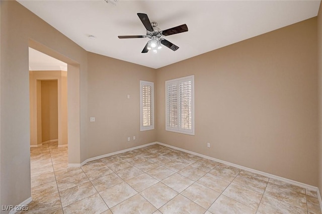 spare room with ceiling fan and light tile patterned floors