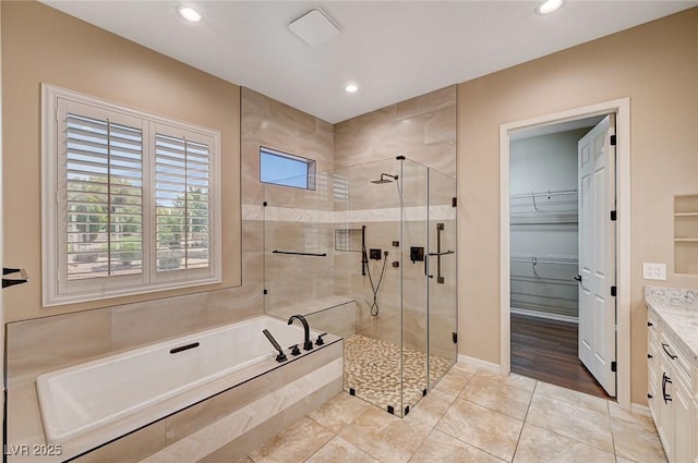 bathroom with tile patterned floors, vanity, and shower with separate bathtub