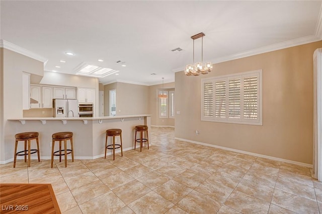 kitchen with kitchen peninsula, a kitchen breakfast bar, refrigerator with ice dispenser, decorative light fixtures, and white cabinetry