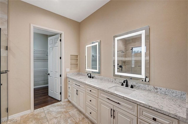 bathroom with a shower, tile patterned flooring, and vanity